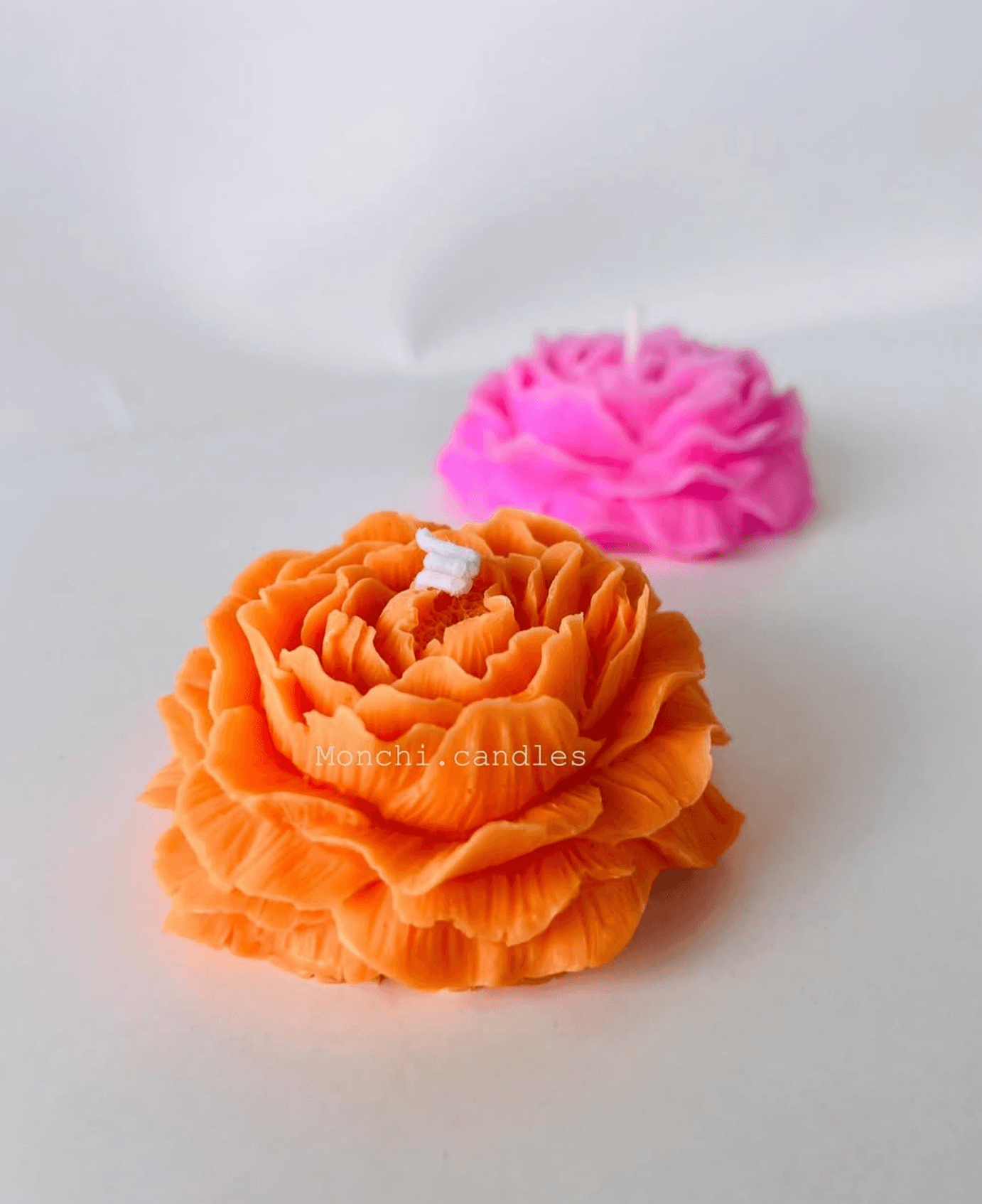 Velas florales naranja y rosa con pétalos detallados