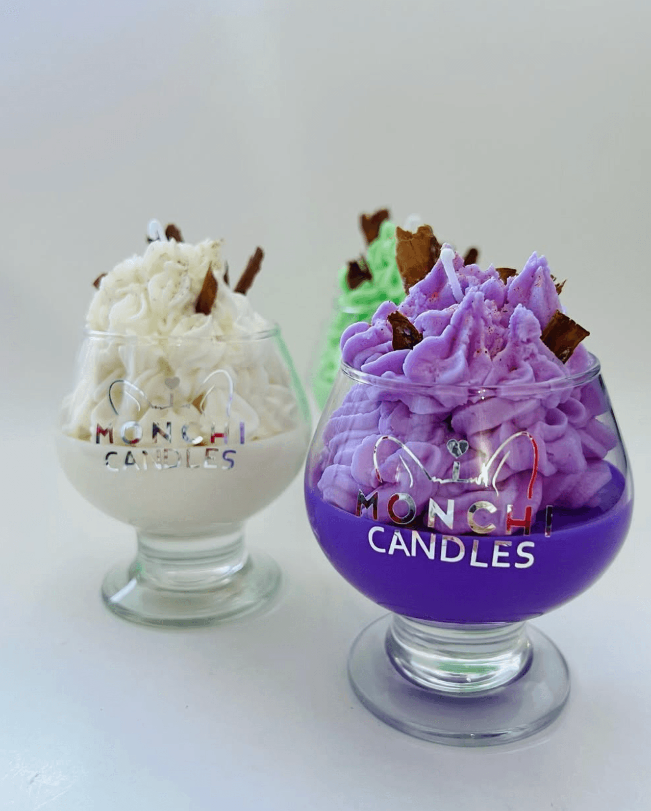 Velas estilo postre en copas con cera batida morada, blanca y verde
